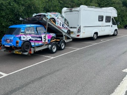 Image of racing cars being towed by a motorhome